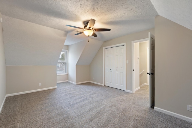 bonus room with lofted ceiling, carpet flooring, a textured ceiling, and ceiling fan