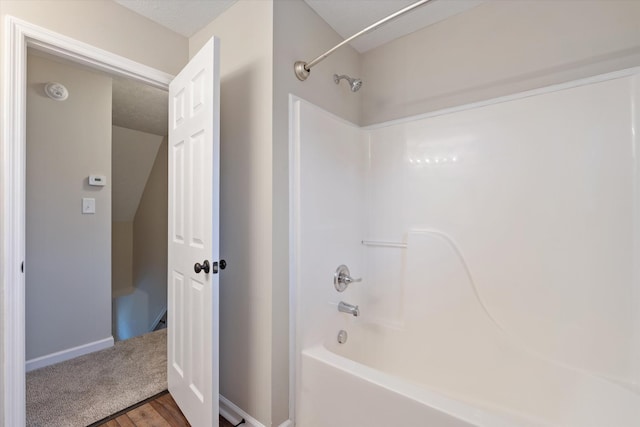 bathroom with hardwood / wood-style flooring and shower / tub combination