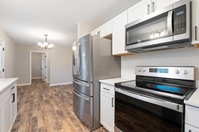 kitchen featuring dark hardwood / wood-style floors, pendant lighting, white cabinets, a chandelier, and stainless steel appliances