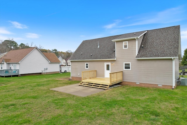 rear view of property with a yard, a deck, and a patio area