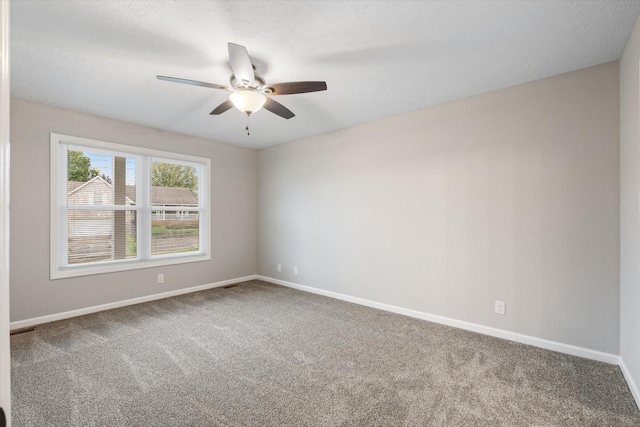 carpeted spare room featuring ceiling fan and a textured ceiling