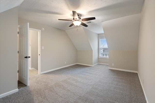 additional living space featuring vaulted ceiling, carpet, ceiling fan, and a textured ceiling