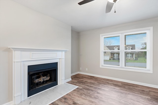 unfurnished living room with ceiling fan and light hardwood / wood-style flooring