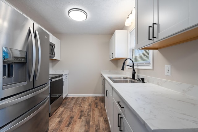 kitchen with sink, white cabinetry, a textured ceiling, appliances with stainless steel finishes, and dark hardwood / wood-style flooring