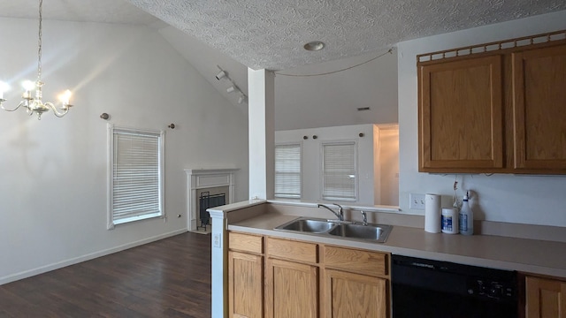 kitchen featuring pendant lighting, sink, dark hardwood / wood-style floors, black dishwasher, and vaulted ceiling