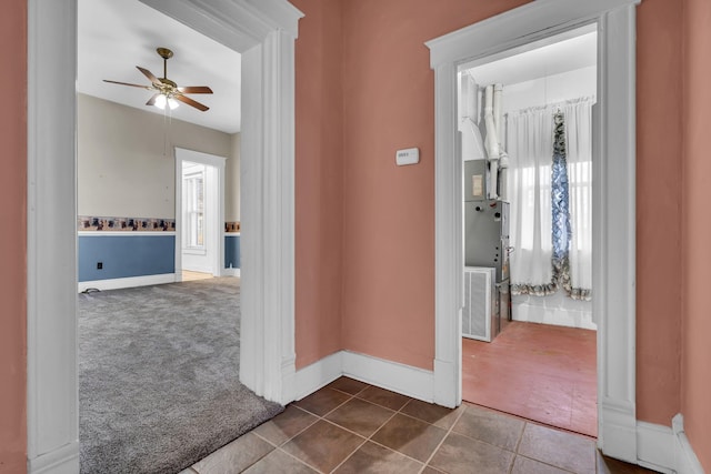 hall featuring dark colored carpet