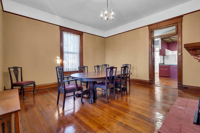 dining space with dark hardwood / wood-style floors and a chandelier