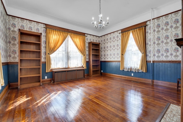 interior space with dark hardwood / wood-style flooring, crown molding, radiator heating unit, and an inviting chandelier