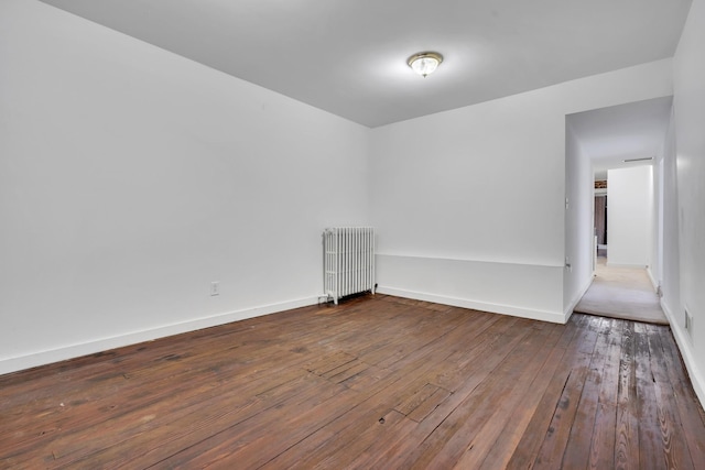 empty room featuring radiator and wood-type flooring