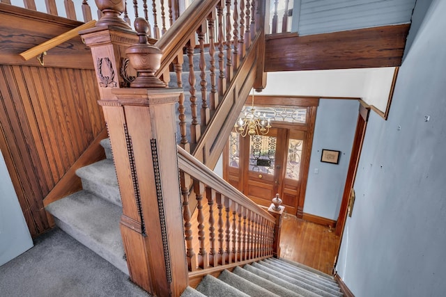 staircase with carpet and a notable chandelier