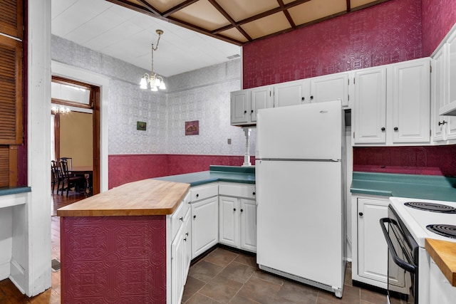 kitchen featuring white appliances, butcher block countertops, a notable chandelier, and white cabinets