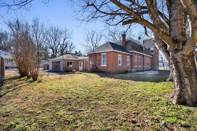 view of side of home with central AC unit and a lawn