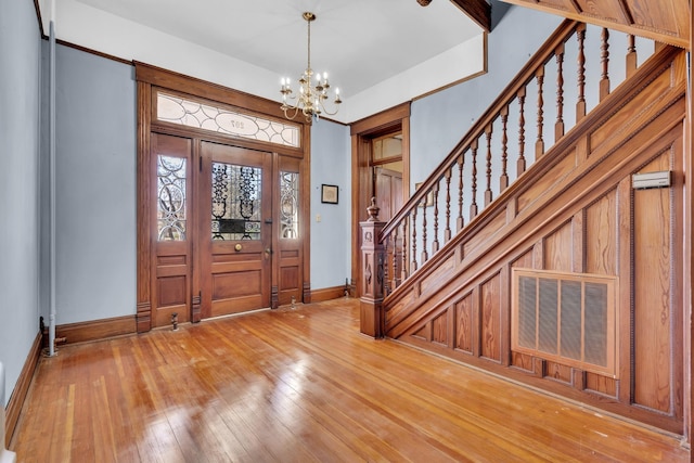 foyer with hardwood / wood-style flooring and a chandelier