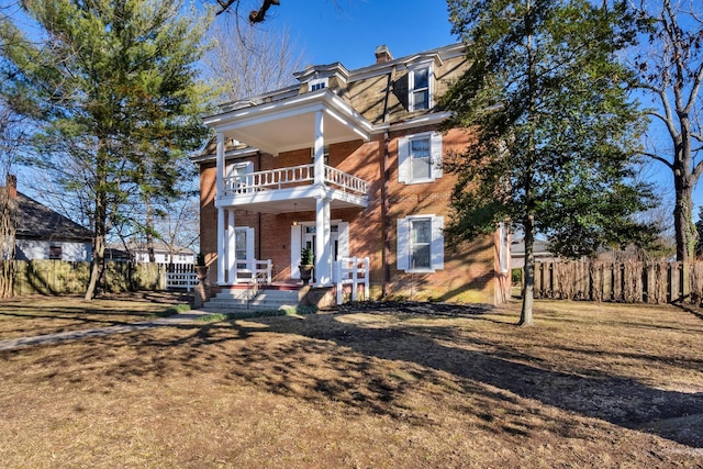 view of front of home featuring a balcony and a front yard