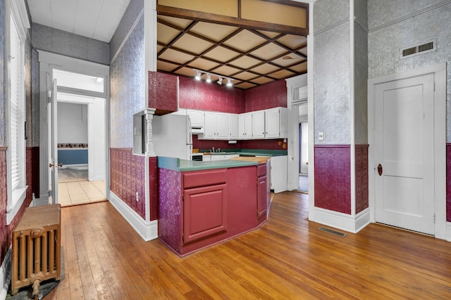 kitchen with refrigerator, light wood-type flooring, and white cabinets