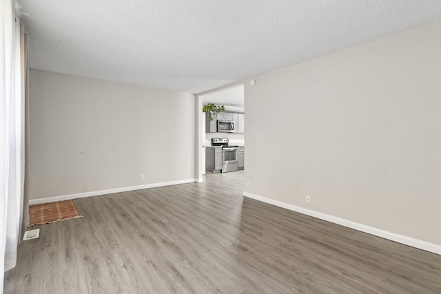 unfurnished living room with hardwood / wood-style flooring and a textured ceiling