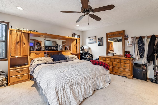 carpeted bedroom with ceiling fan and a textured ceiling