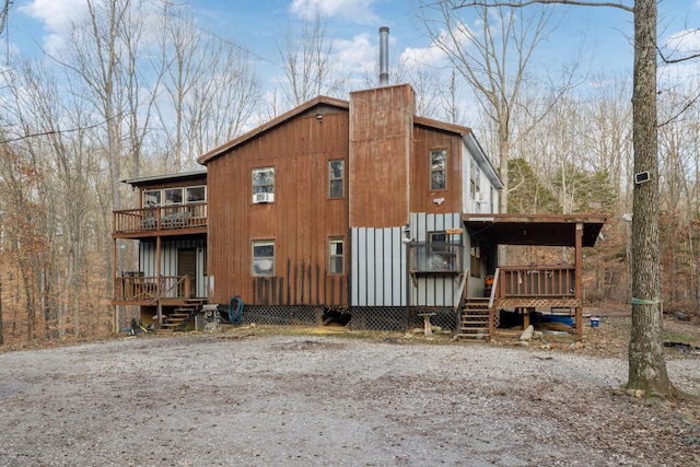 view of side of property featuring a wooden deck and a balcony