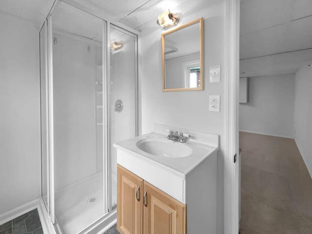 bathroom featuring a paneled ceiling, vanity, and an enclosed shower