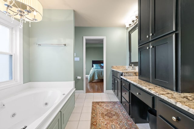 bathroom with tile patterned floors, a chandelier, a bathtub, and vanity