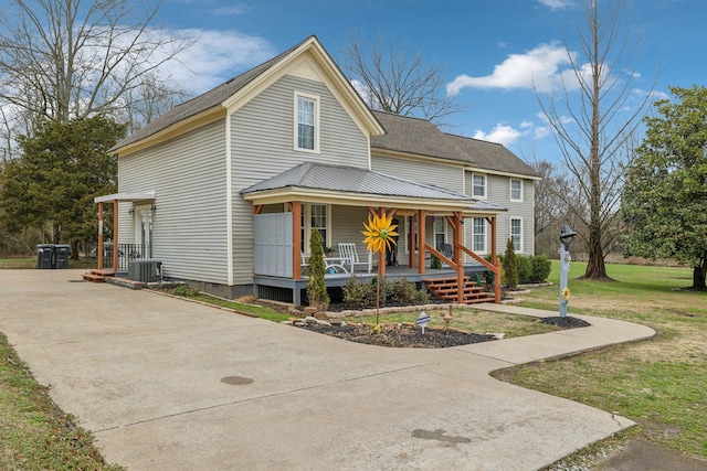 view of front of home with central AC, a front lawn, and a porch