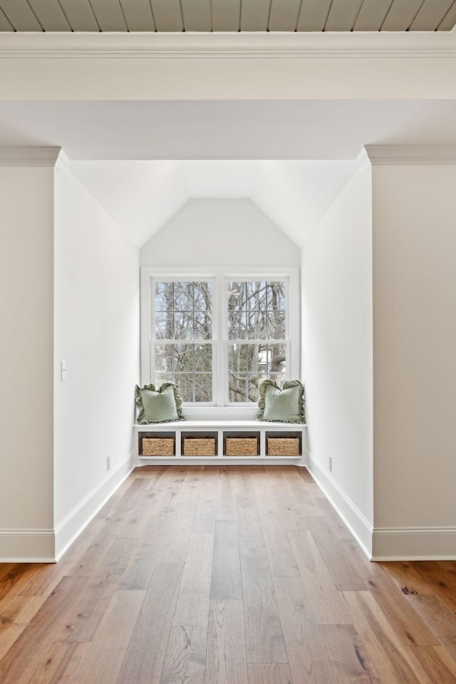 interior space featuring lofted ceiling, light wood-type flooring, and baseboards