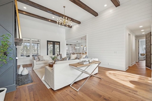 living area featuring a towering ceiling, wood finished floors, beam ceiling, and a healthy amount of sunlight