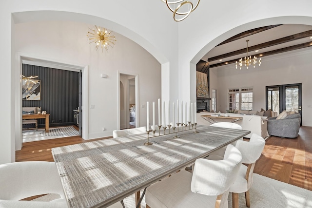 dining space featuring a chandelier, wood finished floors, and beamed ceiling