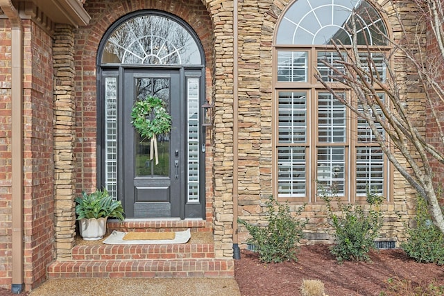 doorway to property with crawl space and brick siding