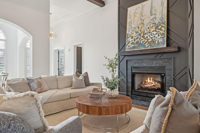 living area with a large fireplace, beamed ceiling, and arched walkways