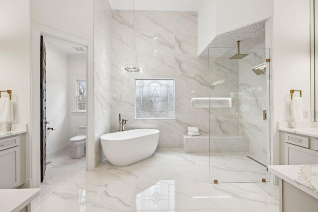 bathroom featuring a freestanding tub, a marble finish shower, and vanity