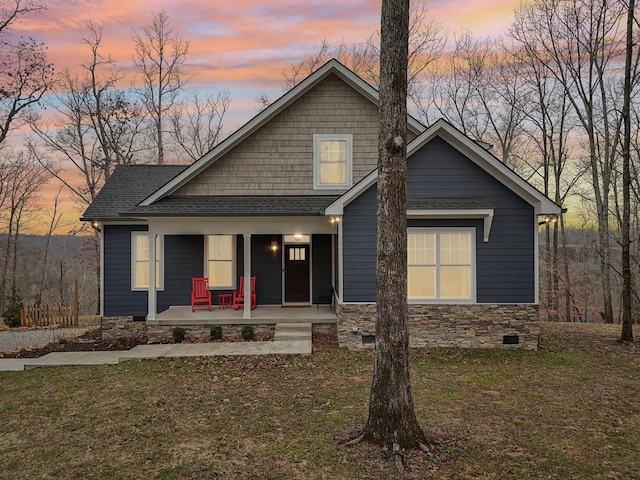 view of front of property with a porch and a yard