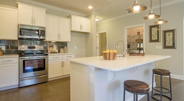 kitchen featuring white cabinetry, appliances with stainless steel finishes, a kitchen island with sink, and pendant lighting