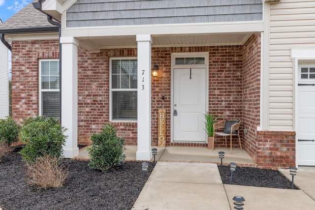 view of exterior entry featuring covered porch