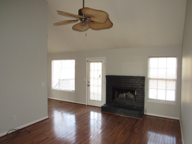 unfurnished living room with lofted ceiling, a fireplace, dark wood-type flooring, and ceiling fan