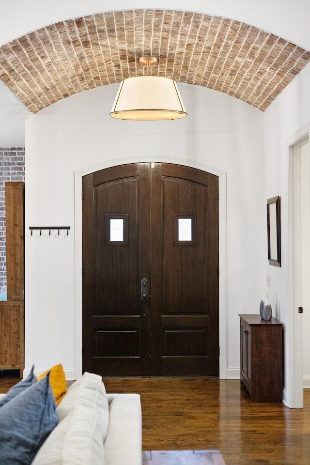 entrance foyer featuring brick ceiling, lofted ceiling, dark hardwood / wood-style flooring, and french doors