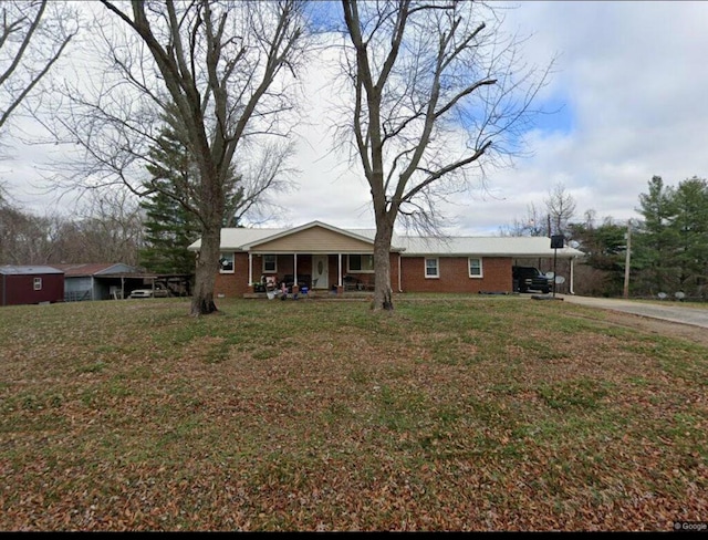 single story home featuring a porch, a carport, and a front yard