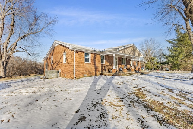 exterior space featuring crawl space, covered porch, central AC, and brick siding