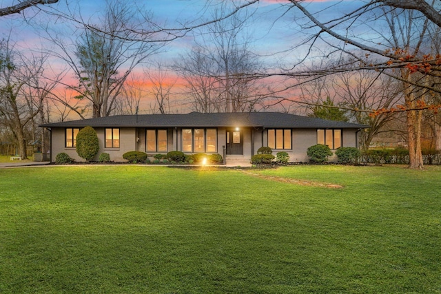 ranch-style home featuring a lawn