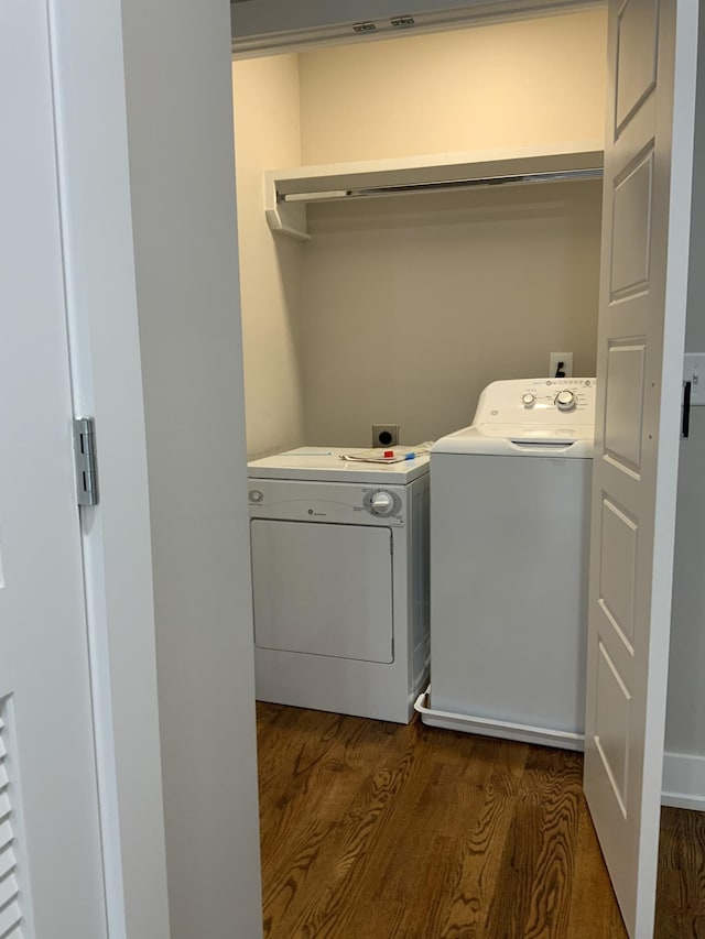 clothes washing area with dark wood-type flooring and washer and dryer