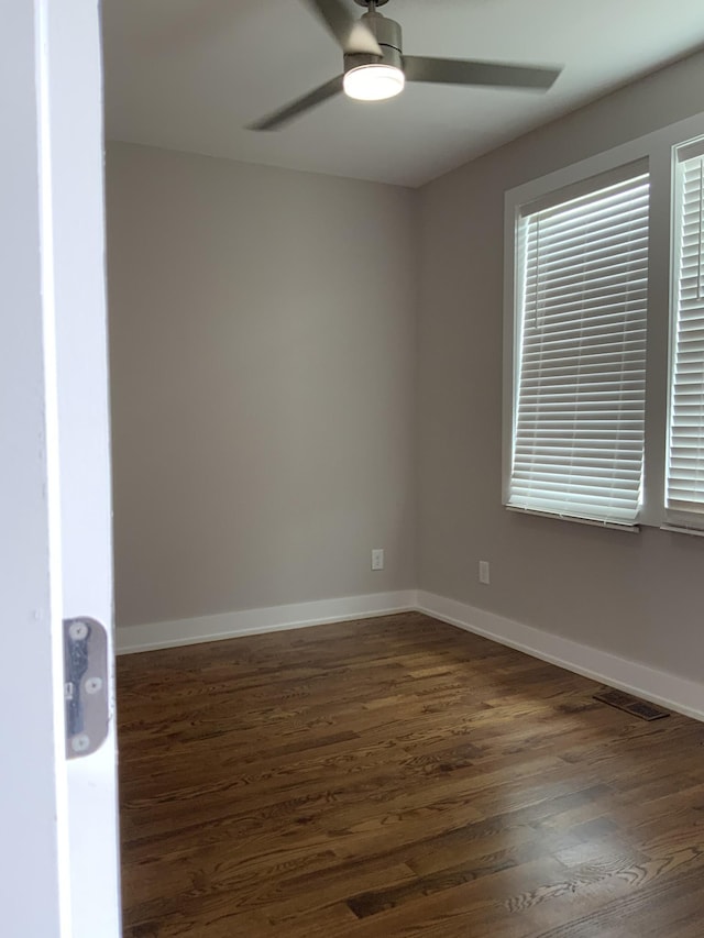 spare room with ceiling fan and dark hardwood / wood-style floors