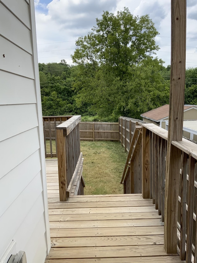 wooden deck featuring a lawn