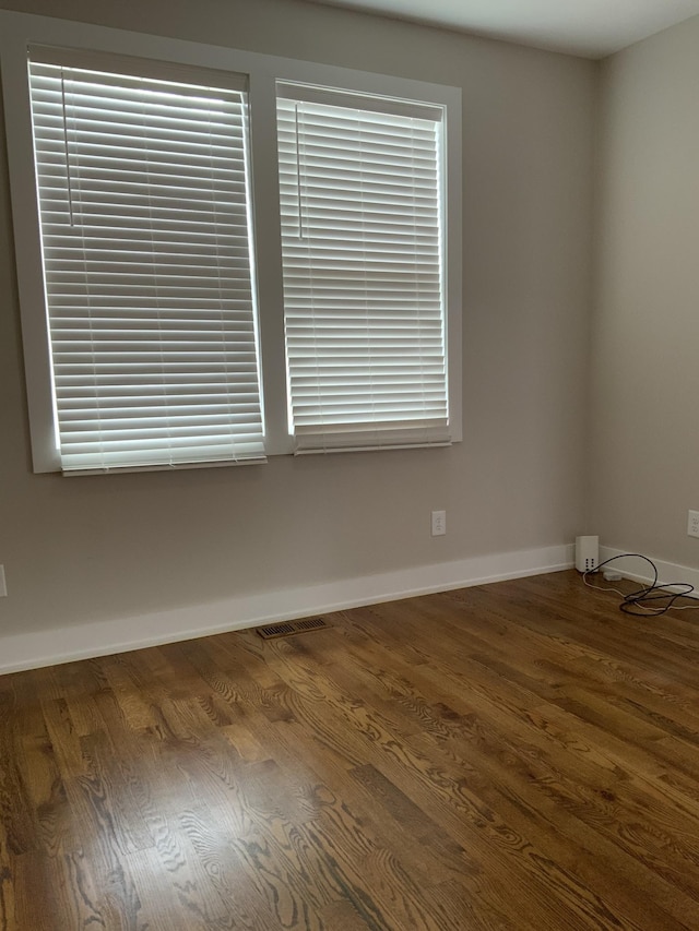 unfurnished room with dark wood-type flooring