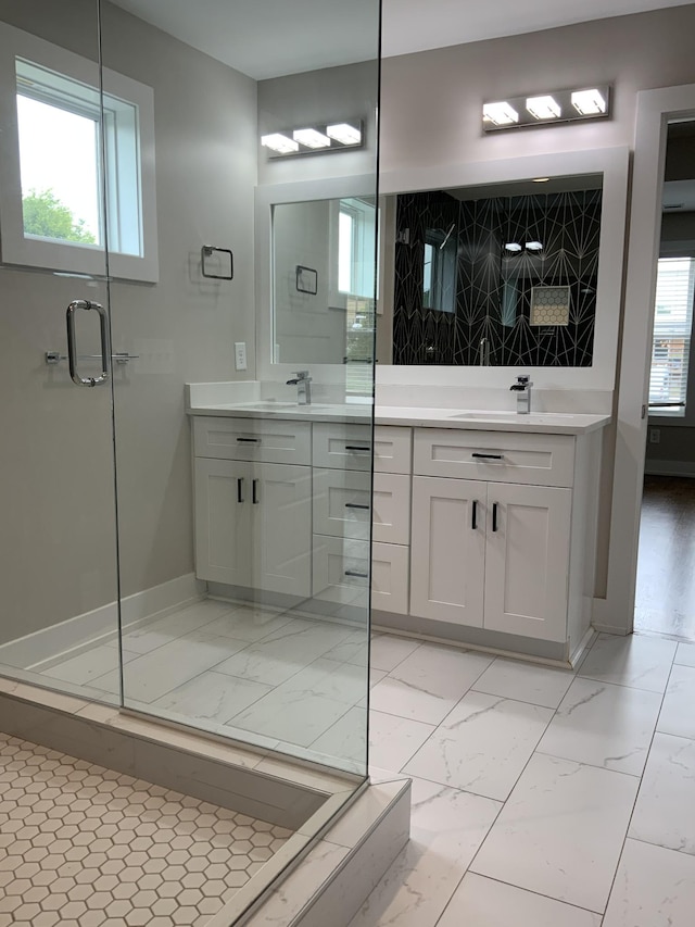 bathroom featuring vanity, a shower with shower door, and a wealth of natural light