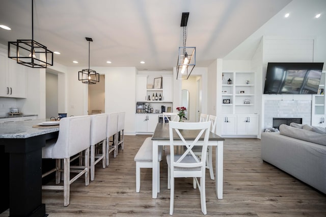 dining area with light wood-type flooring and built in shelves