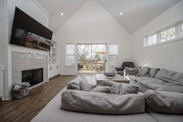 living room featuring a fireplace, dark hardwood / wood-style floors, high vaulted ceiling, and a wealth of natural light