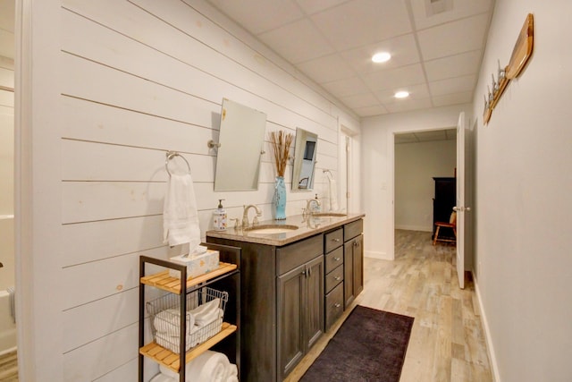 bathroom with vanity, wood-type flooring, and a paneled ceiling