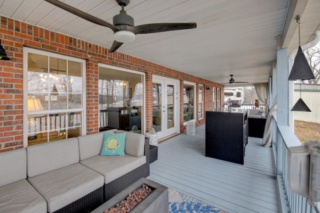 wooden deck featuring an outdoor living space, ceiling fan, and french doors