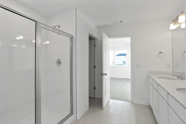 bathroom featuring tile patterned flooring, vanity, and a shower with door