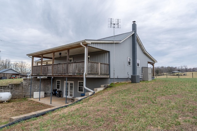 rear view of house featuring a patio, a lawn, and central air condition unit